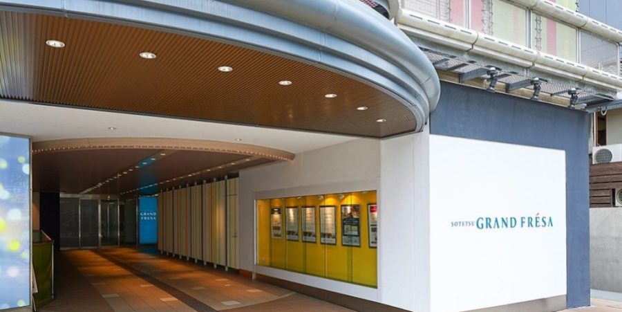 Hotel exterior view showcasing its modern architecture and vibrant signage at night.